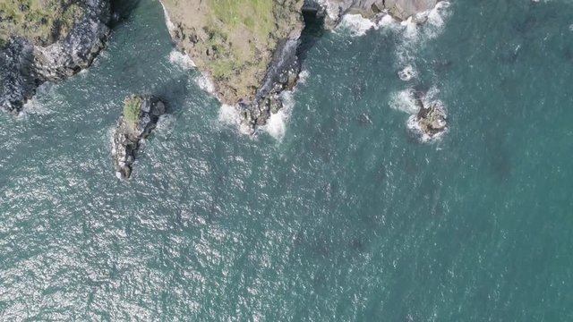 Majestic 4K bird's-eye view aerial of the turquoise North Atlantic ocean and seagulls flying next to the cliffs of Hellnar and Arnarstapi, both popular tourist attraction on the west coast of Iceland.