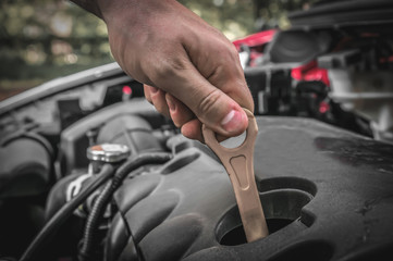 Mechanic checking the oil level in a car engine