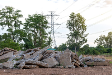 Fototapeta na wymiar Concrete debris piles near rural trees.