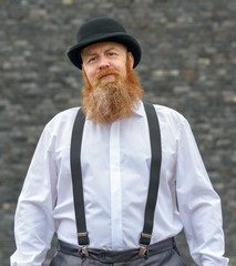 Genial happy bearded man in a bowler hat