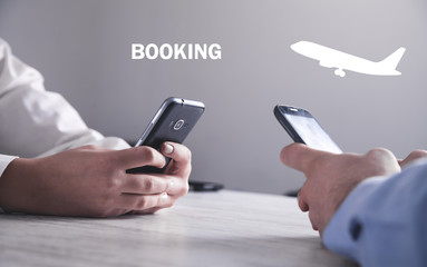 Hand using smartphone. Buying flight ticket. Booking