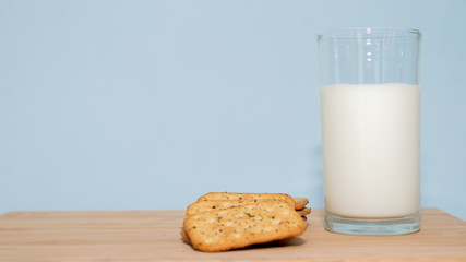 glass of milk and biscuits on wooden table