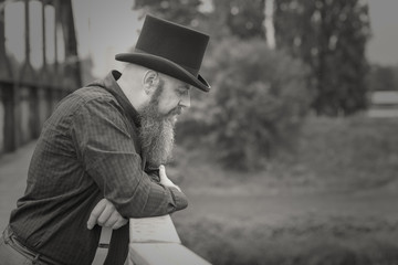 Bearded man in a top hat lost in deep thought