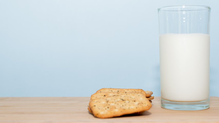 glass of milk and biscuits on wooden table