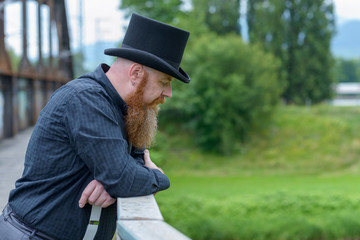 Naklejka na ściany i meble Bearded man in a top hat lost in deep thought