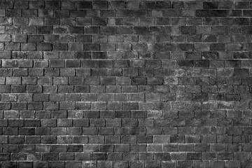 a surface of black the brick from texture. dark background with stone vintage. loft style for web or interior building. Black brick wall texture, surface brick Vintage wallpaper.