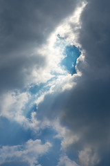 Sun Beam Penerating Thourgh Dark Cloud Over The Blue Sky 