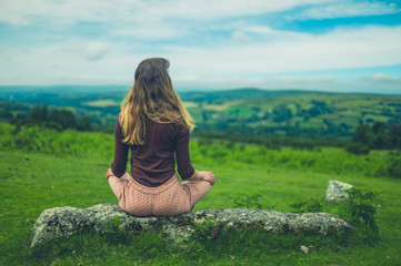 Young woman sitting on a rock in nature