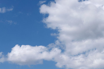 Blue sky texture background with white fluffy clouds. Abstract, cropped shot, horizontal. Nature's concept
