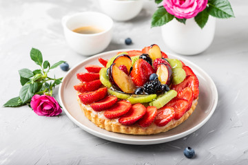 Tart with strawberries, kiwi, plums and cream
