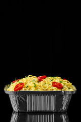 Asian noodle with vegetables closeup on black background. 