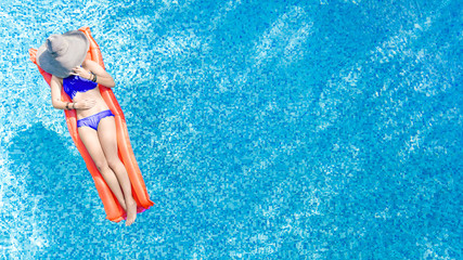 Beautiful young woman in hat in swimming pool aerial top view from above, young girl in bikini...