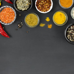 Group of bowls full of spices on black background