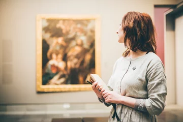 Fotobehang Young woman sketching in Museum. Woman holding the notepad and thinking. © Mariia Korneeva