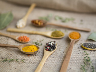 Spoons full of spices on beige fabric