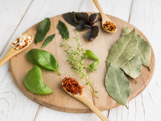 Dry leaves and spices on round wooden tray