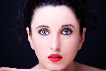 Young attractive woman with long black hair on dark background