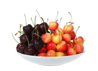 Porcelain bowl full of fresh organic Bing cherries and Rainer Cherries. Bing are dark red and very round, not to mention very sweet, Rainier are sweet and delicious and has a red and yellow color.