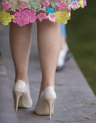 female legs in beige high-heeled shoes