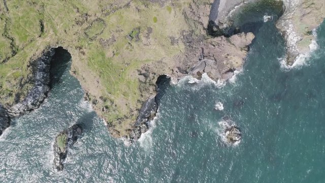 Majestic 4K bird's-eye view aerial of the turquoise North Atlantic ocean and seagulls flying by the cliffs of Hellnar and Arnarstapi, both popular tourist attractions on the west coast of Iceland.