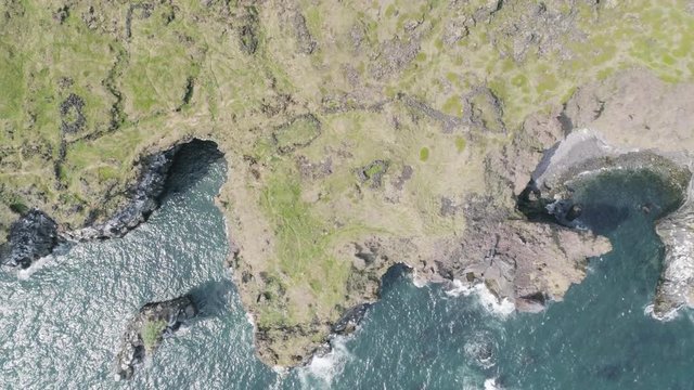 Majestic 4K bird's-eye view aerial of the turquoise North Atlantic ocean and seagulls flying by the cliffs of Hellnar and Arnarstapi, both popular tourist attractions on the west coast of Iceland.