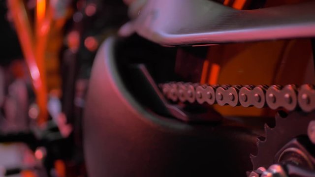 Close Up On The Chain Of An Orange KTM Motorcycle Superduke 1290 in an event with good lights and bokeh