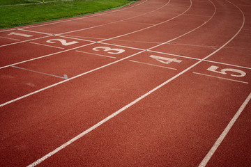 Sport. A red treadmill or athletics track with numner of line at the stadium. Copy space