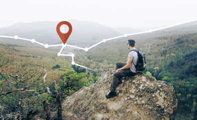 Backpacker man looking at route with location GPS pin in the mountains outdoor.