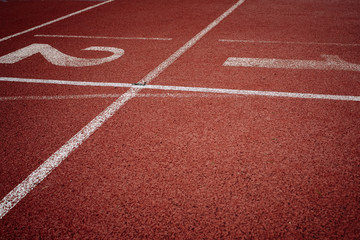 Sport. A red treadmill or athletics track with numner of line at the stadium. Copy space