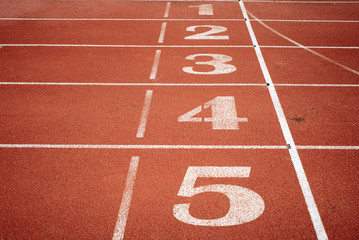 Sport. A red treadmill or athletics track with numner of line at the stadium. Copy space