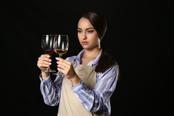 Portrait of elegant female sommelier on dark background