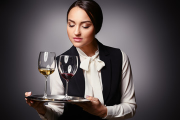 Portrait of elegant female sommelier on dark background