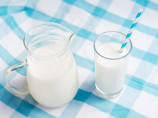 Glass of milk with straw and jar