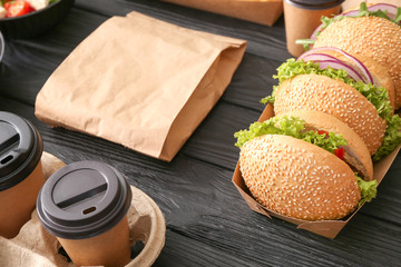 Different tasty food from delivery service on wooden background