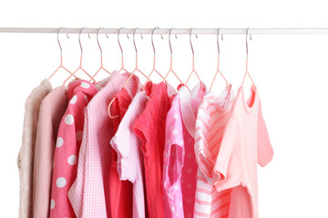 Stylish kid clothes hanging on rack against white background