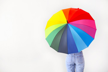 Young woman with stylish umbrella on light background