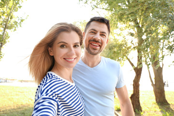 Fototapeta premium Happy couple in love taking selfie outdoors