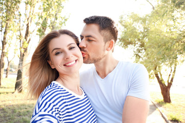 Fototapeta premium Happy couple in love taking selfie outdoors