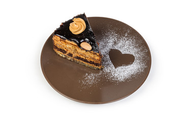 Slice of the layered chocolate sponge cake on brown dish
