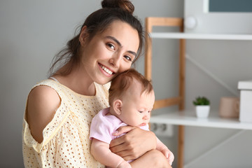 Happy mother with cute little baby at home