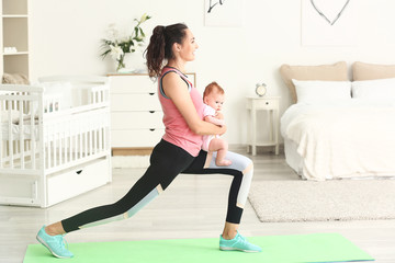 Mother practicing yoga with cute little baby at home