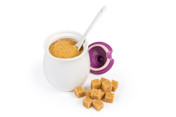 Brown sugar in sugar-bowl and brown sugar cubes beside