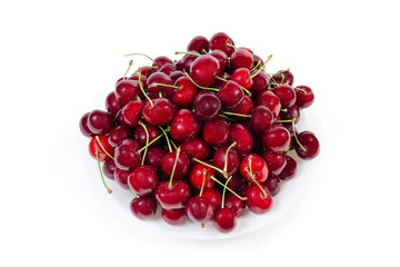 Sweet cherries with stalks on dish on white background