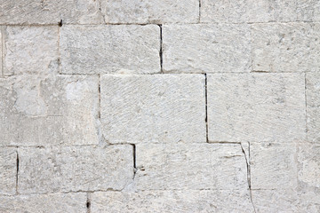 Deep crack in old medieval stone wall made of big blocks