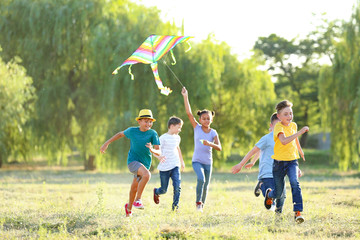 Children flying kite on summer day - Powered by Adobe