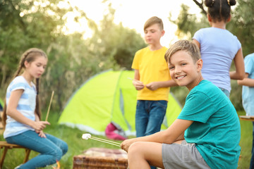 Fototapeta na wymiar Children roasting marshmallow on fire at summer camp