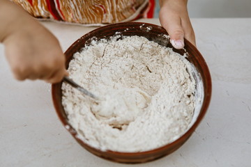 baby hands knead the dough in a pizza plate