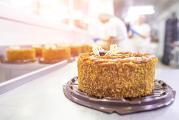 Workers confectioners make biscuit cakes with puff pastry with condensed milk and prunes. Production of sweets and desserts. Food industry, copy space