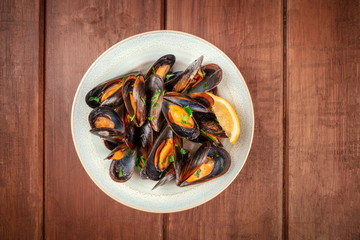Marinara mussels, moules mariniere, shot from above on a dark rustic wooden background