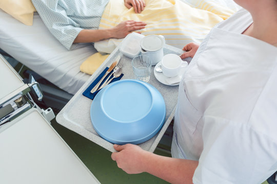 Krankenschwester serviert ein Essen im Krankenhaus direkt ans Bett der Patientin